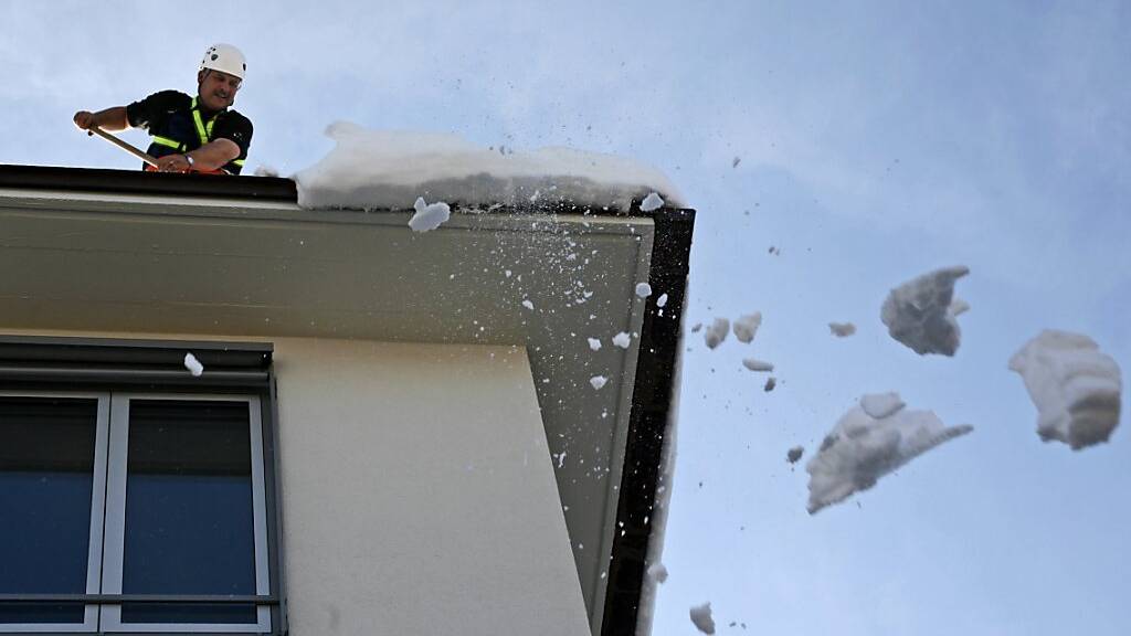 Hauseigentümer sind verpflichtet, Dachlawinen zu verhindern. Im Bild ein gesicherter Feuerwehrmann im März 2006 in Zürich. (Archivbild)