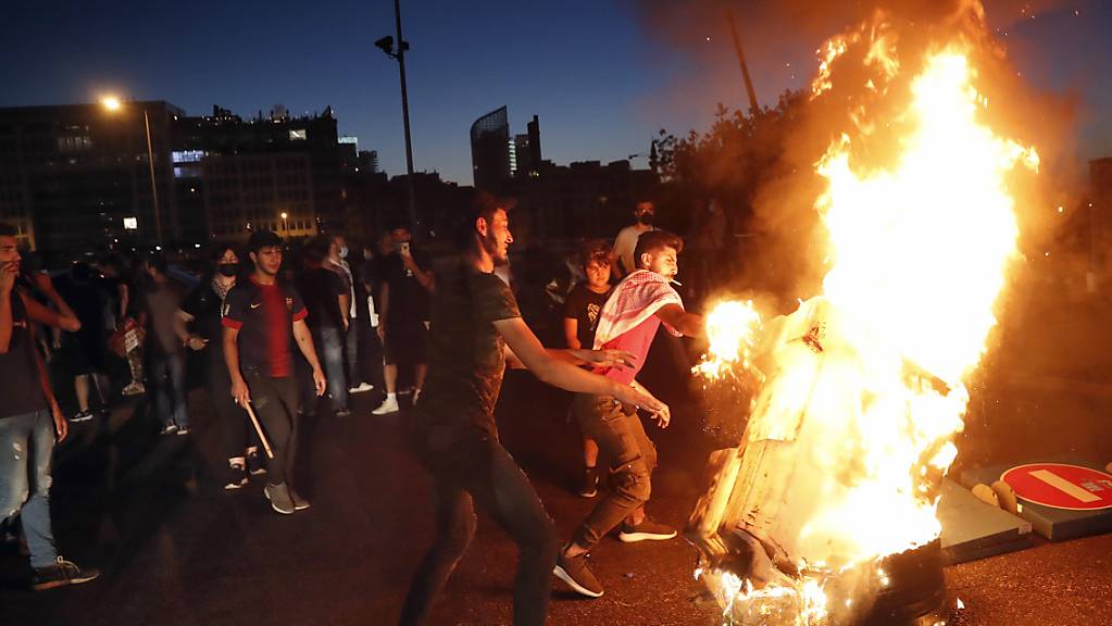dpatopbilder - Demonstranten verbrennen bei einem Protest gegen die politische Elite Gegenstände, um eine Straße zu blockieren. Foto: Hussein Malla/AP/dpa