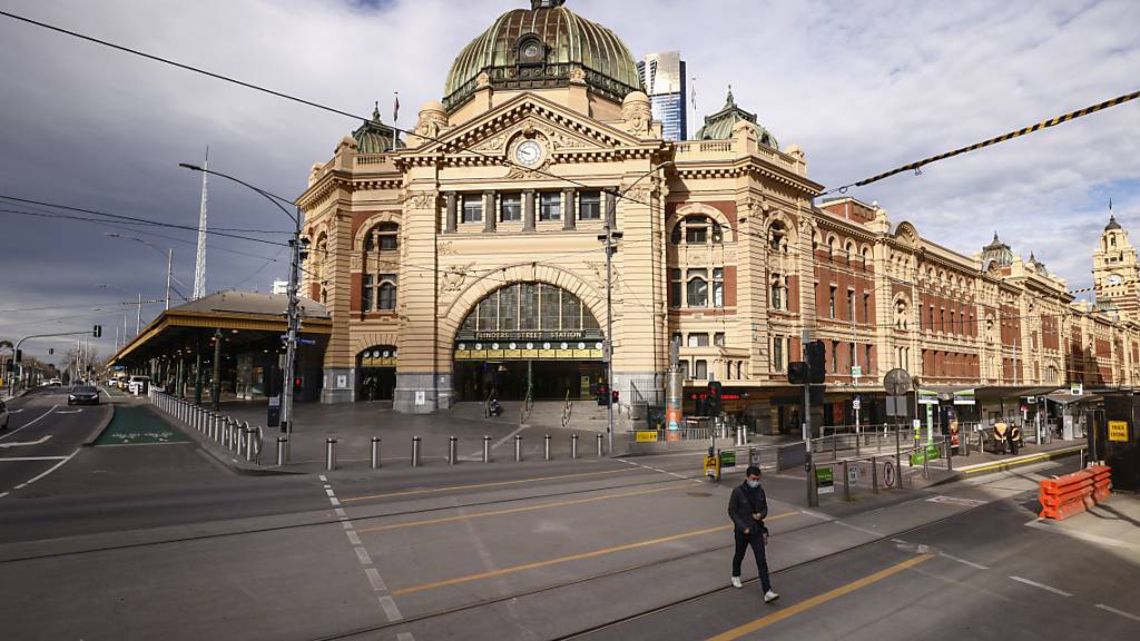 A lone person crosses a quiet Flinders Street in Melbourne, Wednesday, August 11, 2021. Regional Victoria's lockdown is over but people in Melbourne are still days from finding out when theirs will end.  (AAP Image/Daniel Pockett) NO ARCHIVING