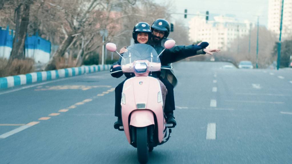 Auf einer rosafarbenen Vespa sausen Filmemacher Bahram und Produzentin Sadaf im Film «Divine Comedy» durch Teheran und suchen nach einem Spielort für ihren neusten Film.