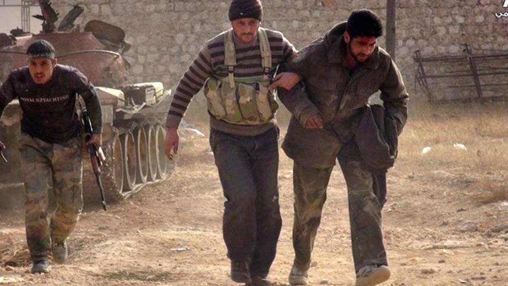 Kämpfer bei Aleppo helfen einem verwundeten Kameraden: Die USA bilden Rebellen in Syrien aus und wollen weitere Spezialeinheiten ins Kriegsgebiet schicken. (Symbolbild)