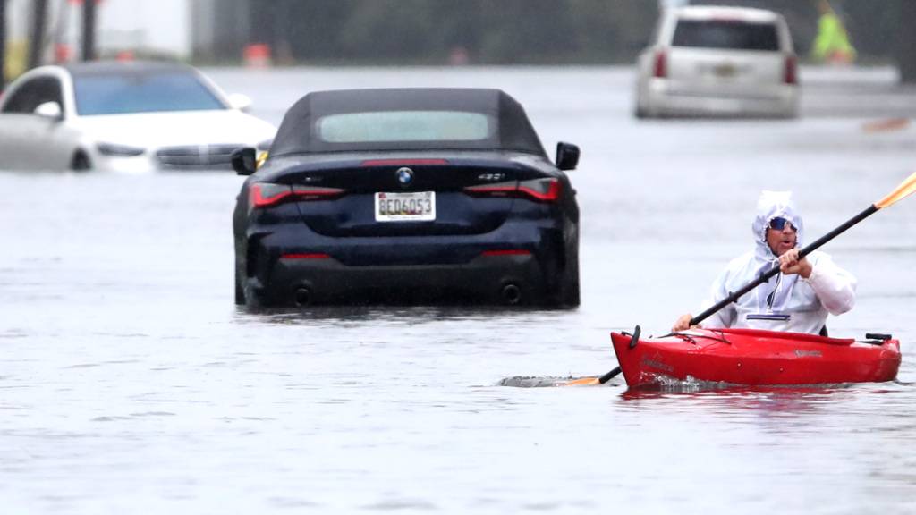 Ted Friedli paddelt während mit seinem Kajak durch einen überfluteten Abschnitt der Florence Avenue. Foto: Noah K. Murray/AP/dpa