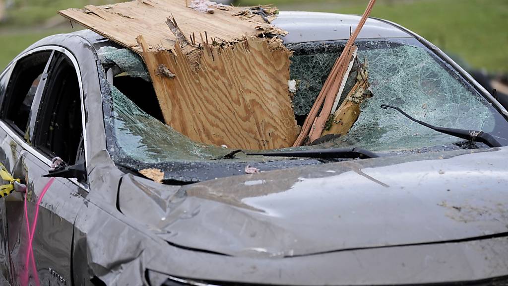 Ein beschädigtes Auto steht nach einem Tornado in Greenfield, Iowa, auf einer Straße. Foto: Charlie Neibergall/AP/dpa