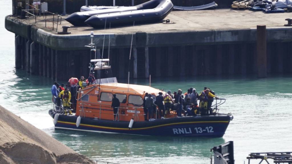 Eine Gruppe von Menschen, bei denen es sich vermutlich um Migranten handelt, wird nach einem Zwischenfall nach Dover gebracht. Foto: Gareth Fuller/PA/AP/dpa - ACHTUNG: Nur zur redaktionellen Verwendung bis 17.09.2024 und nur mit vollständiger Nennung des vorstehenden Credits