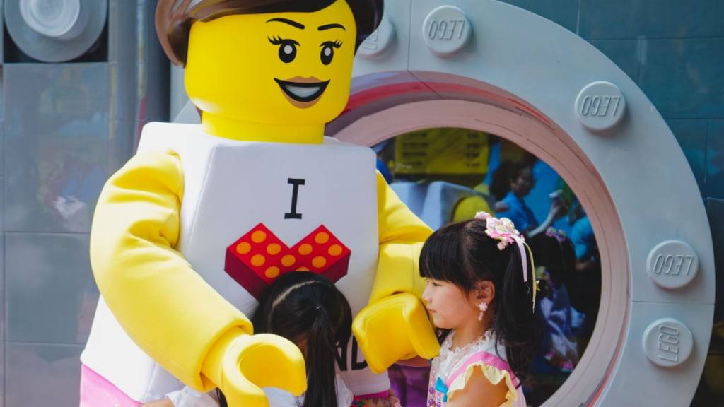 Kinder umarmen im neuen Legoland in Shanghai ein Maskottchen des Spielwarenherstellers. (Archivbild)