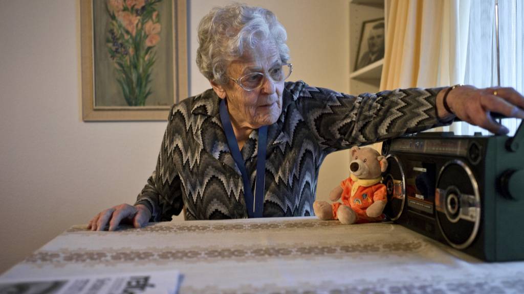 Wie soll künftig in Notfällen kommuniziert werden? Im Bild hört eine ältere Frau im Wohnzimmer ihrer Wohnung Radio.