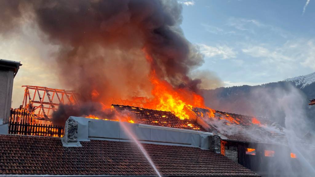 Der Dachstock eines Stalls im Dorfzentrum von Domat/Ems GR steht in Vollbrand.