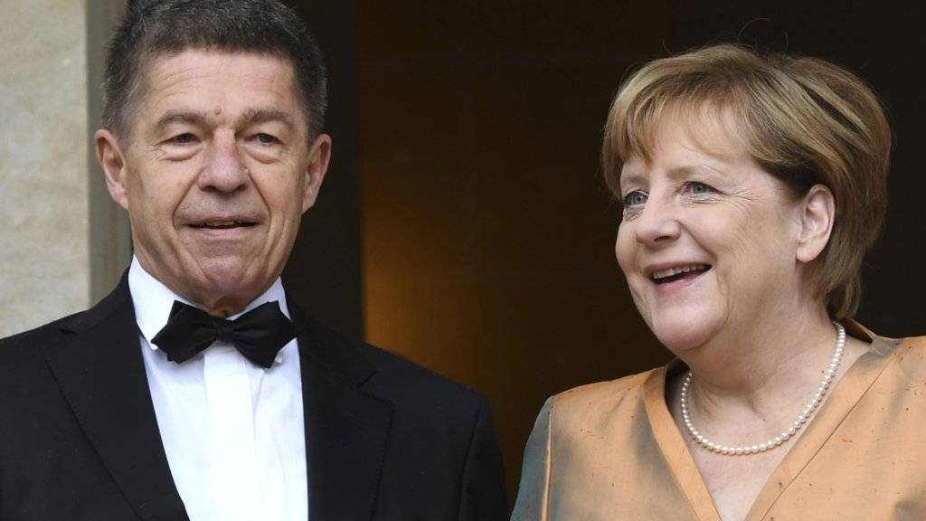 Angela Merkel und ihr Mann Joachim Sauer freuten sich, als sie endlich nach dem verregneten roten Teppich in Bayreuth auf dem Trockenen waren.