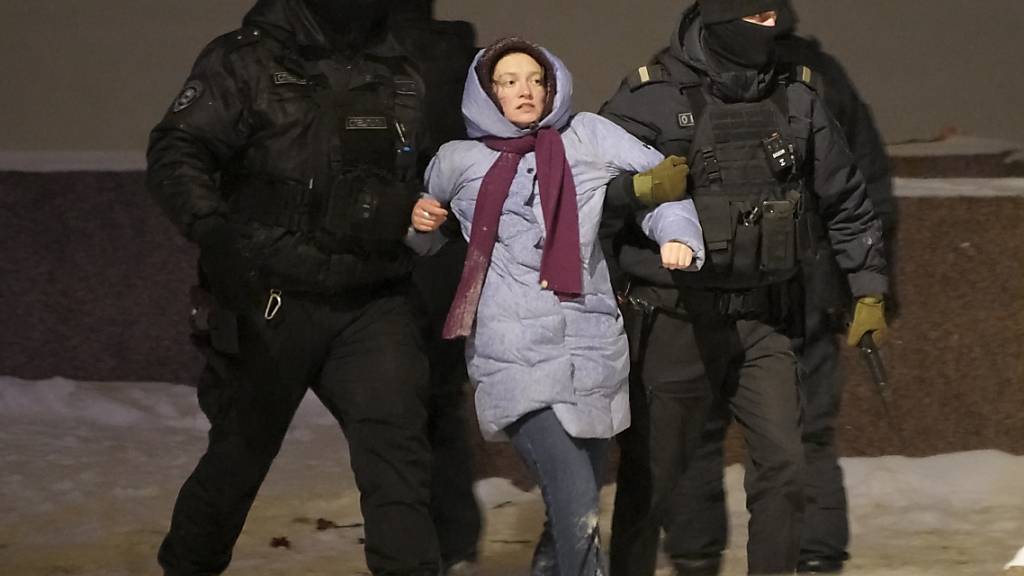 dpatopbilder - Polizeibeamte halten eine Frau fest, die Blumen für den verstorbenen russischen Oppositionellen Nawalny niederlegt hat. Foto: Uncredited/AP/dpa