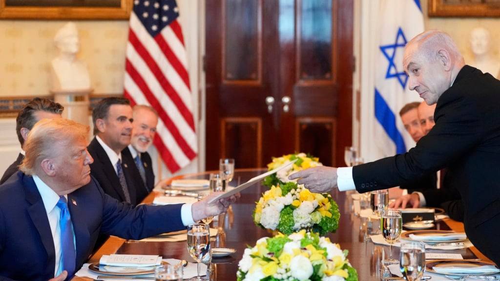 dpatopbilder - Benjamin Netanjahu (r), Ministerpräsident von Israel, überreicht US-Präsident Donald Trump eine Mappe während eines Treffens im Blue Room des Weißen Hauses in Washington. Foto: Alex Brandon/AP/dpa