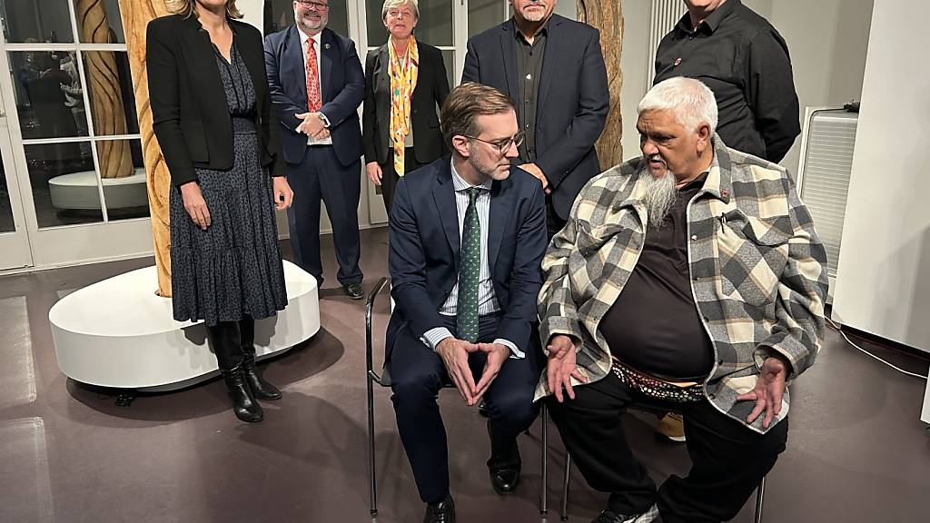 Feierliche Rückgabe des Thulu-Baums vom Museum der Kulturen Basel an die australische Ureinwohner-Gemeinschaft der Gamilaraay mit Vetreterinnen und Vertretern der Gemeinschaft, des Museums, der Basler Regierung und der Botschafterin Australiens in der Schweiz, Elisabeth Day (ganz links).