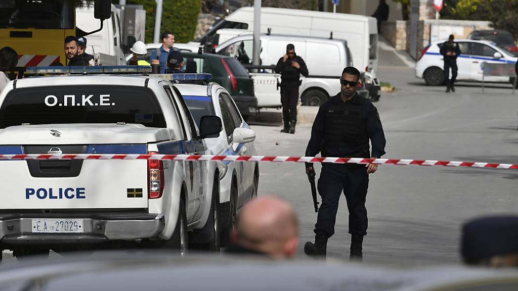 Die Polizei sperrt während eines Einsatzes im südlichen Vorort Glyfada eine Straße ab. Ein Mann ist in die Büros einer Reederei in der Athener Vorstadt Glyfada eingedrungen und soll dort drei Menschen erschossen haben. Foto: Michael Varaklas/AP/dpa