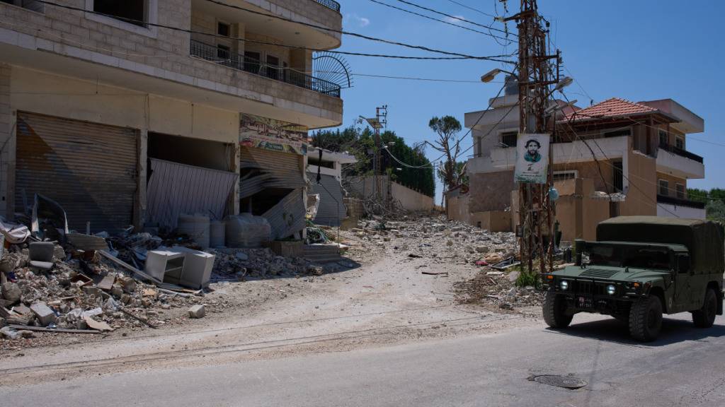 ARCHIV - Ein Fahrzeug der libanesischen Armee fährt an beschädigten Gebäuden im Dorf Dibbine im Südosten des Libanon vorbei. Die israelische Armee hat ihre Angriffe im südlichen Libanon nach dortigen Angaben trotz des verkündeten Rahmenabkommens im Iran-Krieg vorerst fortgesetzt. Foto: Hassan Ammar/AP/dpa/Archivbild