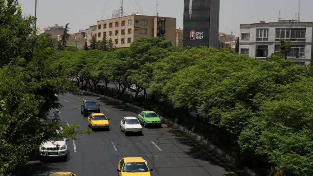 Fahrzeuge fahren in der iranischen Hauptstadt an einer Plakatwand vorbei, auf der ein Porträt des verstorbenen iranischen Obersten Führers Ajatollah Ali Chamenei zu sehen ist. Foto: Vahid Salemi/AP/dpa