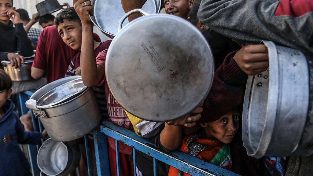 Palästinenser stehen an, um eine Mahlzeit zu erhalten. Foto: Abed Rahim Khatib/dpa