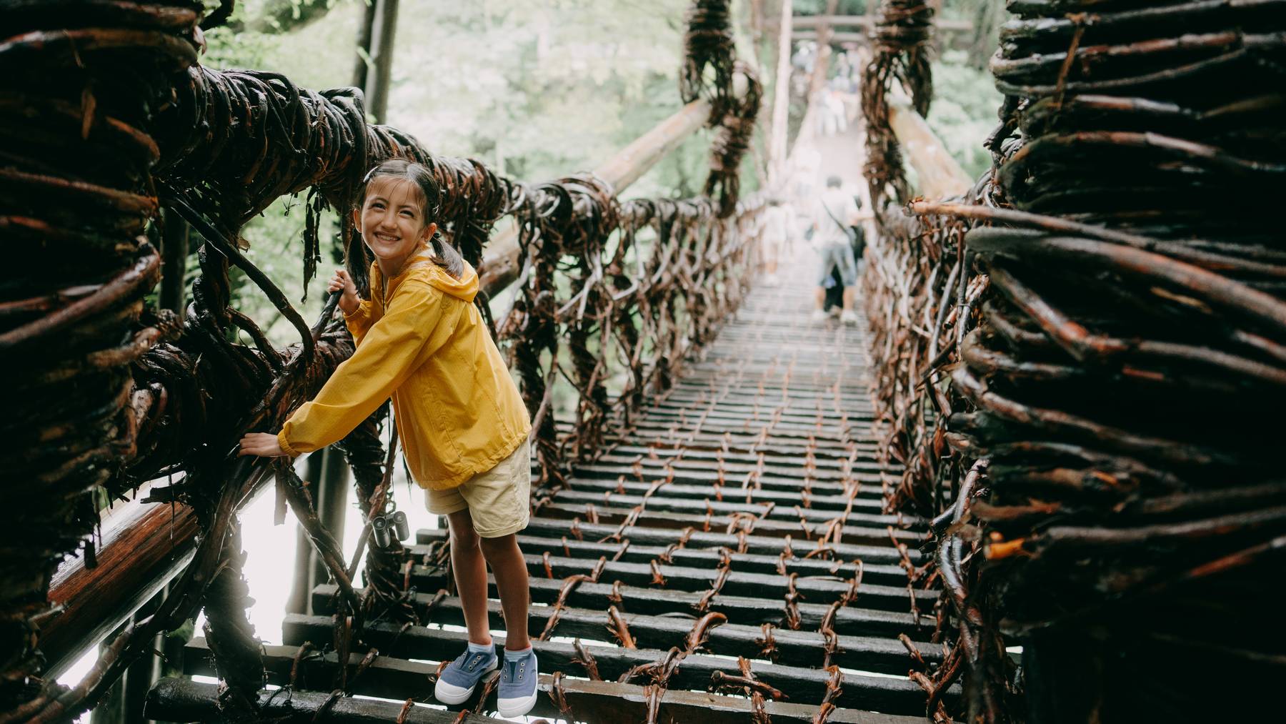 Young girl crossing vine bridge, Iya Valley, Shikoku, Japan