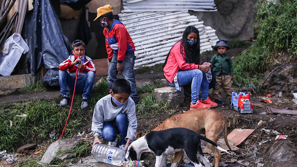 Ein Bub und zwei Hunde in einem Elendsviertel im kolumbianischen Bogotá.