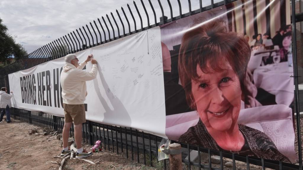 Jeff Robb aus Seattle, der in Tucson überwintert, unterschreibt auf einem Banner zur Unterstützung von Nancy Guthrie. Fast zwei Wochen wird die Mutter von US-Moderatorin Savannah Guthrie vermisst. Das FBI verdoppelte zuletzt die Belohnung für Hinweise zum Verschwinden der Mutter Guthries. Foto: Ty ONeil/AP/dpa