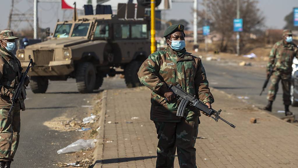 Bewaffnete Soldaten patrouillieren außerhalb eines Einkaufszentrums. In Südafrika setzten sich die tagelangen gewalttätigen Proteste fort. Foto: Themba Hadebe/AP/dpa