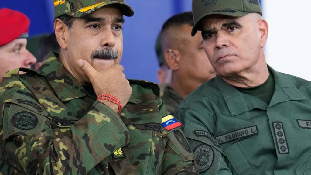 ARCHIV - Der venezolanische Präsident Nicolás Maduro (l) hört Verteidigungsminister Lopez während eines von der Regierung organisierten zivil-militärischen Marsches zu. Foto: Ariana Cubillos/AP/dpa