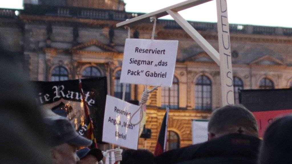 Pegida-Anhänger tragen bei einer Demo in Dresden einen für die deutsche Kanzlerin Merkel und Vizekanzler Gabriel reservierten Galgen mit sich - nun ermittelt die Justiz. (Archiv)
