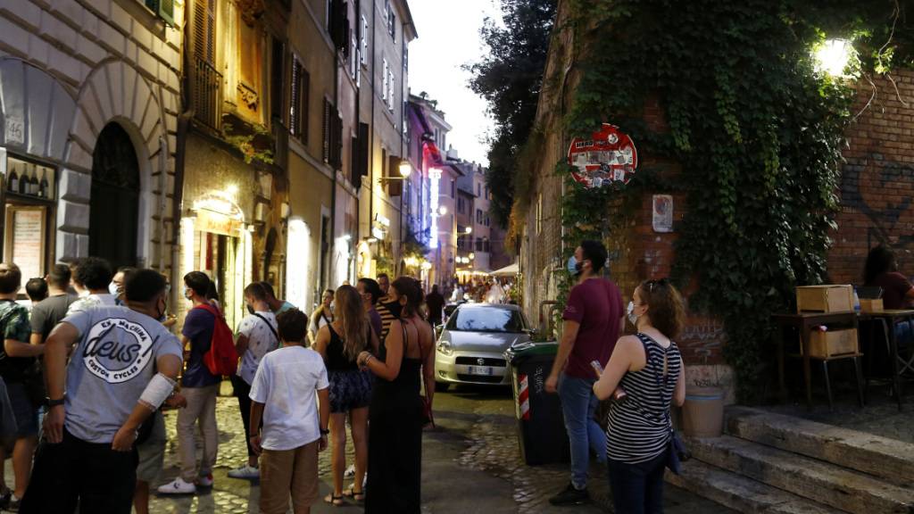 ARCHIV - Gäste stehen mit Mundschutzen vor einem Restaurant an. Italiens Regierung bereitet nach Medienberichten eine erneute Verschärfung der Anti-Corona-Maßnahmen vor, um den steilen Anstieg der Ansteckungszahlen zu bremsen. Foto: Cecilia Fabiano/LaPresse via ZUMA Press/dpa