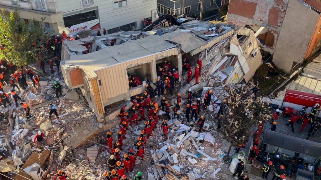 Feuerwehrleute und Rettungskräfte suchen nach dem Einsturz eines Wohngebäudes nach Verschütteten. Foto: Cihan Atik/IHA/AP/dpa