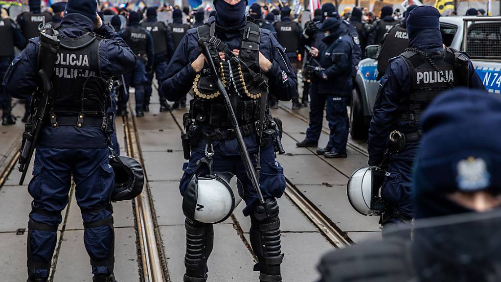 Polizisten in Schutzuniform stehen während einer Demonstration in der Hauptstadt Wache. Foto: Grzegorz Banaszak/ZUMA Wire/dpa