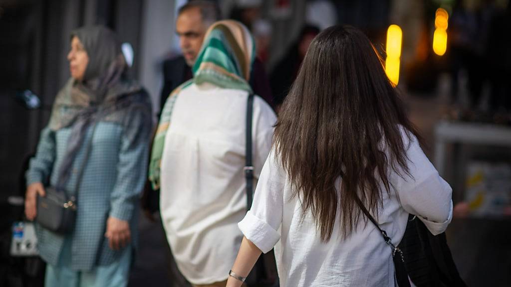 ARCHIV - Eine Frau läuft in Teheran mit offenen Haaren am Abend eine Straße entlang. Irans Behörden haben die Rückkehr der berüchtigten Sittenwächter zur Vollstreckung der Kopftuchpflicht angekündigt. Foto: Arne Bänsch/dpa