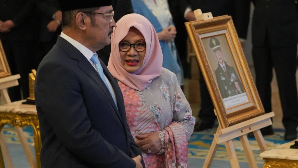 Siti Hardiyanti Rukmana (2.v.l), Tochter des verstorbenen Präsidenten Suharto, und dessen Sohn Bambang Trihatmojo (l) stehen neben dem Porträt ihres Vaters während einer Zeremonie zur Verleihung des Status «Nationalheld» an zehn Persönlichkeiten, darunter der ehemalige indonesische Machthaber, im Staatspalast ausgestellt. Foto: Achmad Ibrahim/AP/dpa