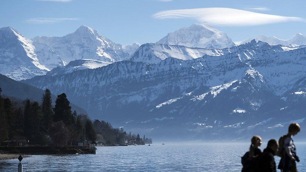 Frühlingshafte Bedingungen im Berner Oberland: Sonnenhungrige geniessen das milde Wetter mit Blick auf Eiger, Mönch und Jungfrau im Schadaupark in Thun BE.