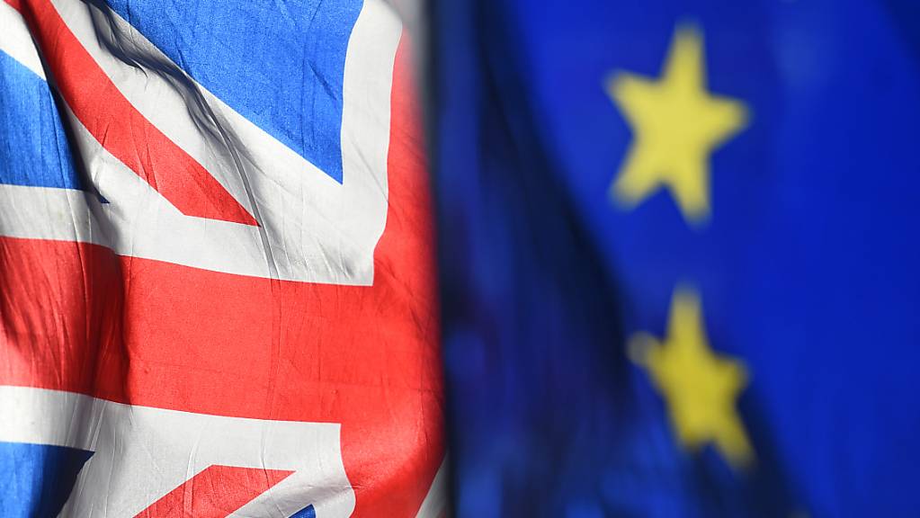 Eine Flagge der Europäischen Union und eine Flagge von Grossbritannien wehen vor dem Parlament in Westminster.