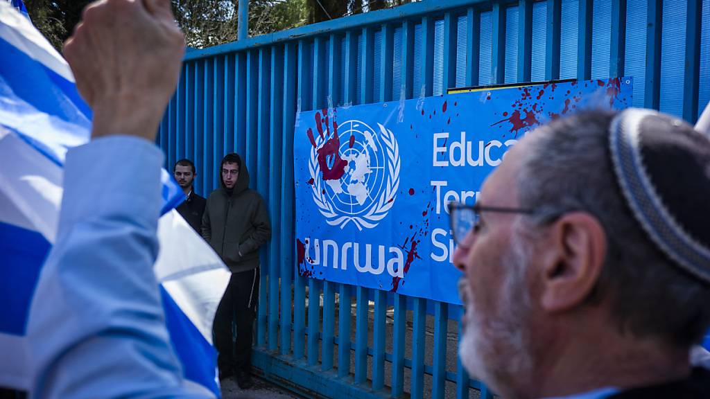 ARCHIV - Israelische Aktivisten nehmen an einem Protest teil, als sie den Eingang zum Büro des UN-Palästinenserhilfswerks (UNRWA)  blockieren. Foto: Ilia Yefimovich/dpa