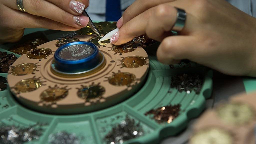 Eine Mitarbeiterin einer Uhrenfirma baut ein Quarzuhrwerk zusammen. Berufe wie Uhrmacher und Mikromechaniker haben 2015 erneut mehr Lernende angezogen. (Archiv)