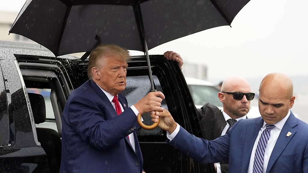 ARCHIV - Walt Nauta (r), Leibwächter des Ex-US-Präsidenten Trump, reicht Donald Trump (l), einen Regenschirm, bevor er am Ronald Reagan Washington National Airport eine Rede hält. Der frühere US-Präsident hat Medienberichten zufolge auch die weiteren Anklagepunkte in der Dokumentenaffäre vor Gericht formell zurückweisen lassen. Foto: Alex Brandon/AP/dpa