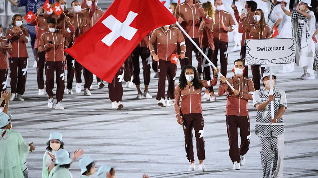 Max Heinzer und Mujinga Kambundji tragen die Schweizer Fahne ins Olympiastadion in Tokio