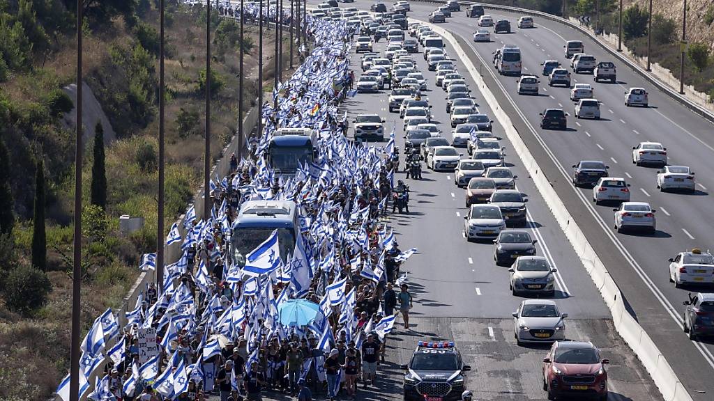 Israelis marschieren auf dem Highway 1 in Richtung Jerusalem, um gegen die umstrittene Justizreform zu protestieren. Foto: Ohad Zwigenberg/AP/dpa