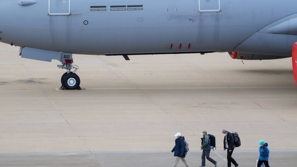 Passagiere des von einem Hantavirus-Ausbruch betroffenen Kreuzfahrtschiffs steigen am Flughafen Eindhoven aus einem Flugzeug aus. Das von der Kanaren-Insel Teneriffa kommende Flugzeug landete mit insgesamt 26 Passagieren und Crewmitgliedern der «Hondius». Foto: Christoph Reichwein/dpa