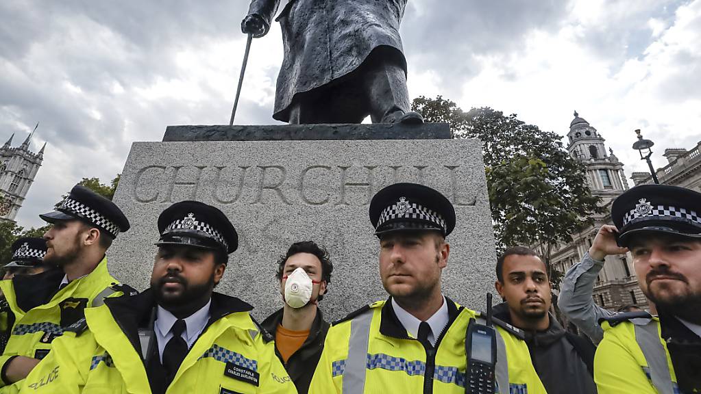 ARCHIV - Polizisten stehen um die Sir Winston Churchill-Statue auf dem Parliament Square während einer Kundgebung zum Gedenken an George Floyd. Foto: Kirsty Wigglesworth/AP/dpa