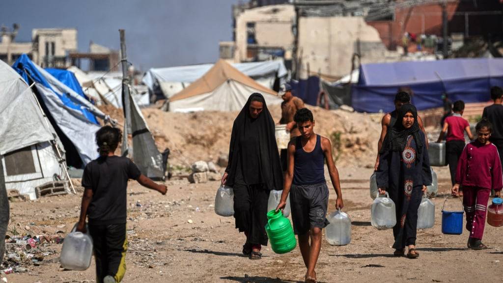ARCHIV - Palästinenser tragen Kanister und Plastikflaschen mit Wasser, nachdem sie es in einem Lager für Vertriebene in Gaza gesammelt haben. (zu dpa: «Wasserversorger im Gazastreifen nimmt Arbeit wieder auf») Foto: Abdel Kareem Hana/AP/dpa