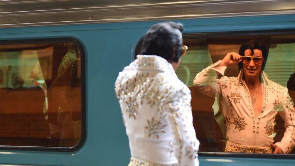 Nein, Elvis lebt definitiv nicht mehr: Der Kult um seine Person ist aber noch immer ungebrochen, wie die vielen Elvis-Doppergänger im Bahnhof Sydney derzeit zeigen.