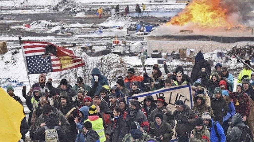Nach fast einem Jahr ist das Protestlager gegen den Bau einer umstrittenen Ölpipeline im Norden der USA geräumt worden. Die Demonstranten verliessen singend und trommelnd das Protestlager auf der vorgesehenen Pipeline-Route. Dabei setzten sie auch einige ihrer Zelte und Hütten in Brand.