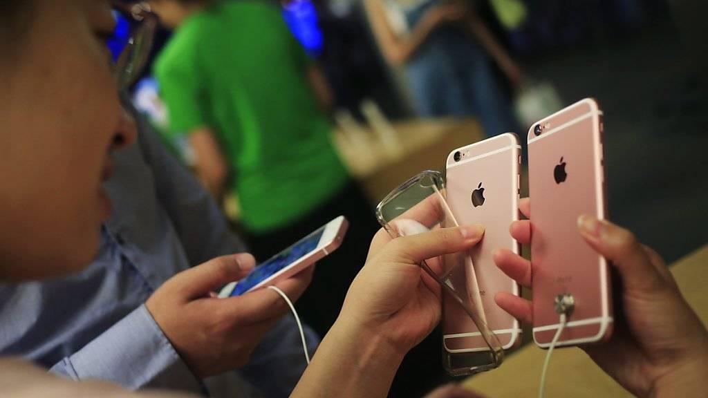 Chinesische Kundschaft begutachtet iPhones in einem Geschäft in Peking
