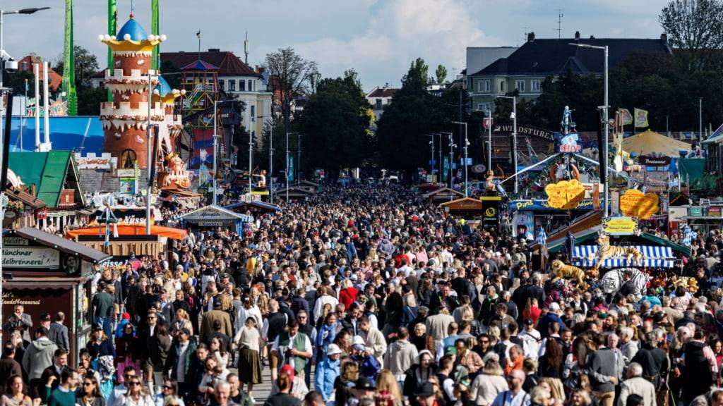Zahlreiche Besucher gehen über das Oktoberfestgelände. Nach dem Brand im Münchner Norden, Schüssen und einer Bombendrohung gegen das Oktoberfest dauern die Ermittlungen in München weiter an. Foto: Matthias Balk/dpa