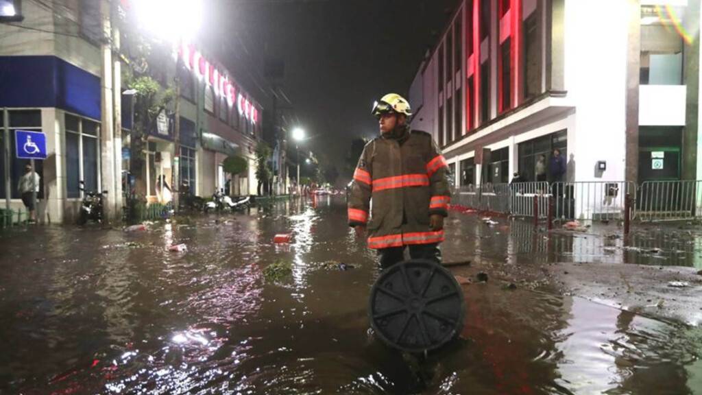 Ein Feuerwehrmann steht in einer überfluteten Straße in Ecatepec. Aufgrund starker Regenfälle am Montag kam es im Zentrum von Ecatepec im Bundesstaat Mexiko zu Überschwemmungen. Foto: El Universal/El Universal via ZUMA Press Wire/dpa