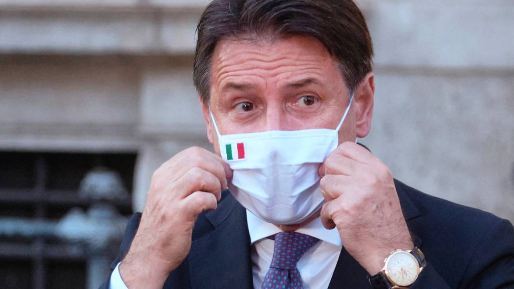ARCHIV - Giuseppe Conte, Ministerpräsident von Italien, richtet seinen Mund-Nasen-Schutz bei einer Pressekonferenz. Foto: Mauro Scrobogna/LaPresse/AP/dpa