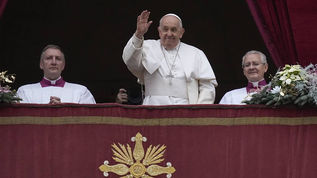 dpatopbilder - Papst Franziskus winkt vom Hauptbalkon des Petersdoms im Vatikan, bevor er den den Weihnachtssegen «Urbi et Orbi» spendet. Foto: Gregorio Borgia/AP