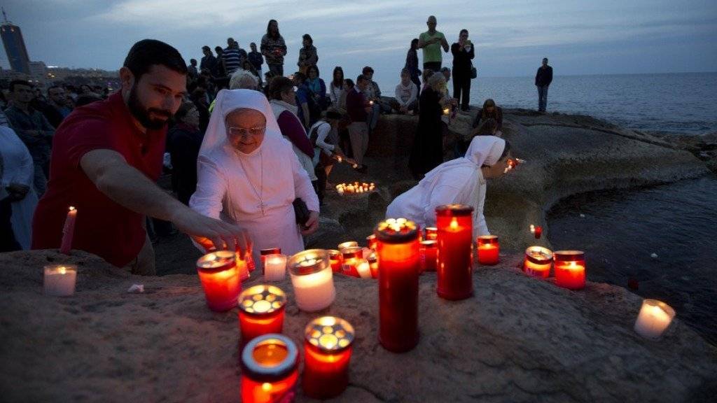 Menschen entzünden an der Küste von Malta Kerzen für die Opfer des im April 2015 vor der libyschen Küste gesunkenen Schiffes. (Archiv)