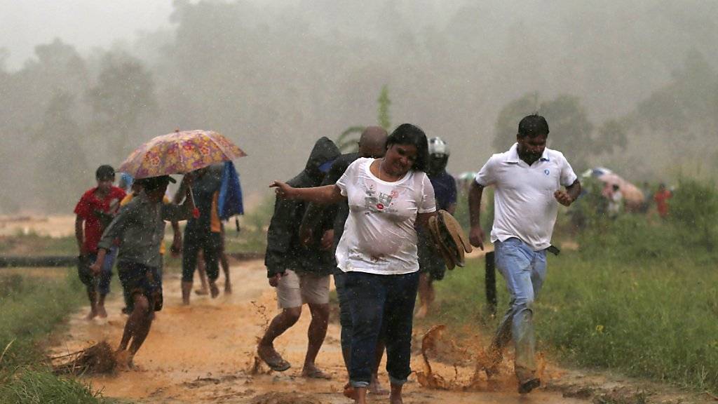 Auch rund um die Hauptstadt Colombo haben die Unwetter Schäden angerichtet - diese Menschen fliehen vor einem Erdrutsch aus ihrem Dorf.