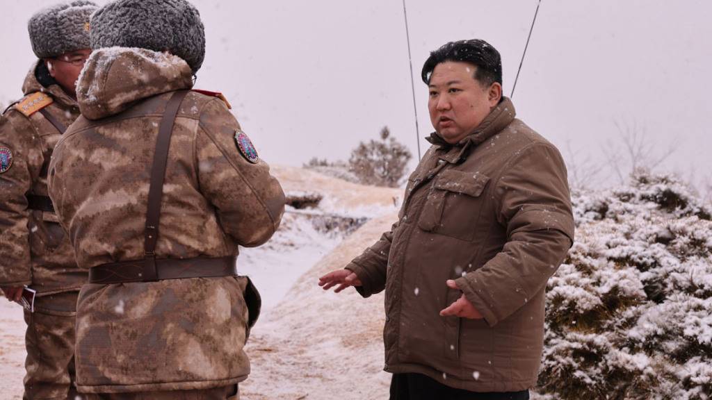 HANDOUT - Nordkoreas Machthaber Kim Jong Un (r.) und Soldaten im Gespräch. Foto: kcna/dpa